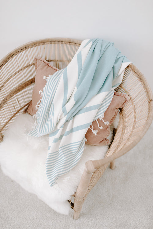 throw made of turkish cotton with tassels and stripes on a chair